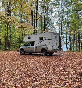 Northstar camper in trees with fall leaves on the ground