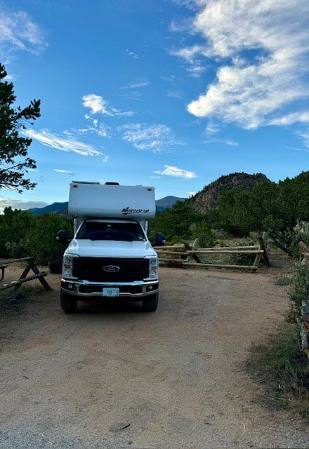 Northstar camper in trees with fall leaves on the ground